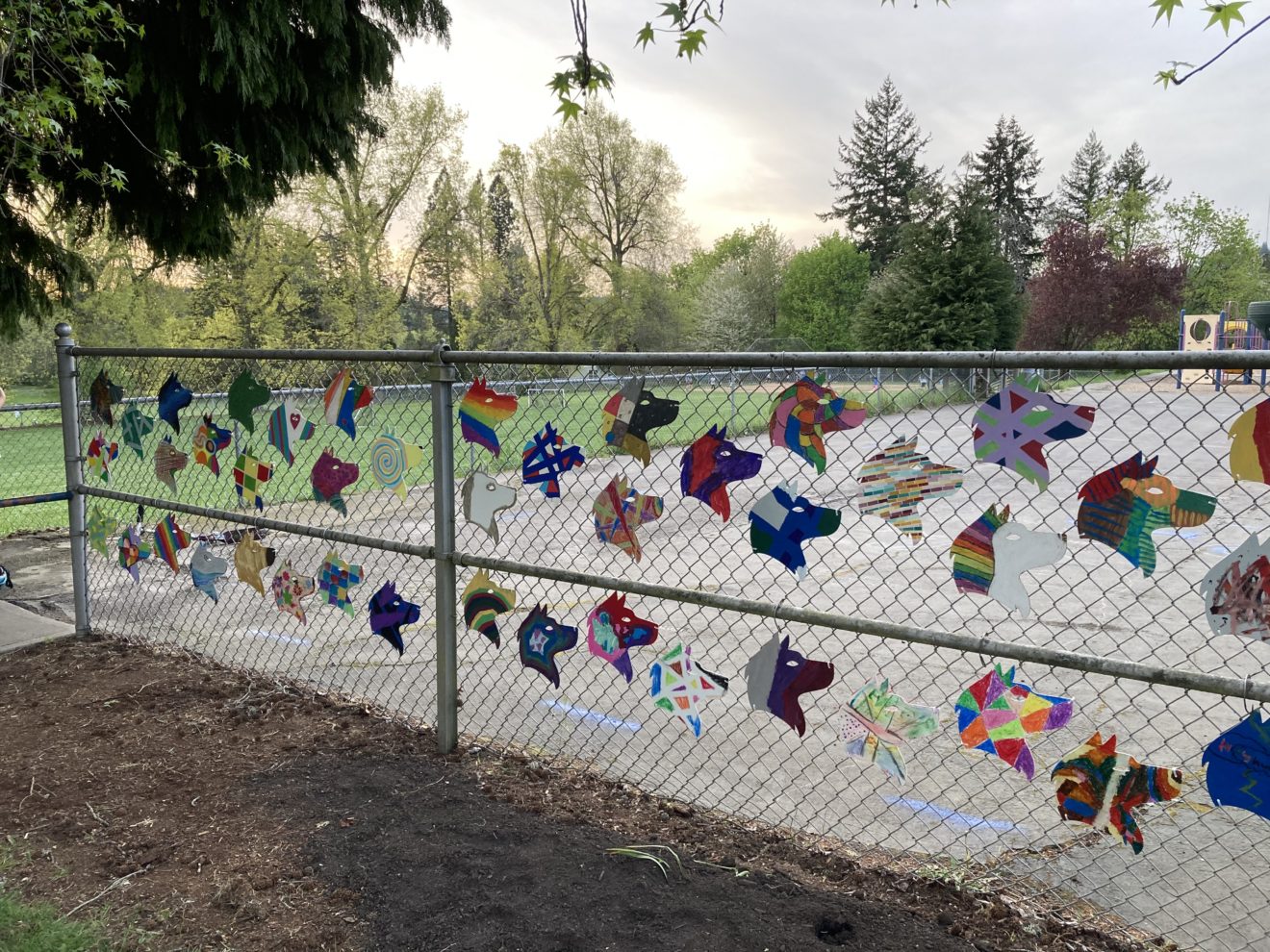 Student decorated Hayhurst Husky Heads hung on the fence in front of the school.